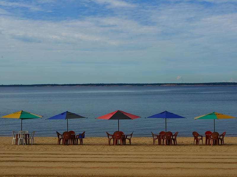Chaises et parasols colorés sur la plage de Ponta Negra à Manaus