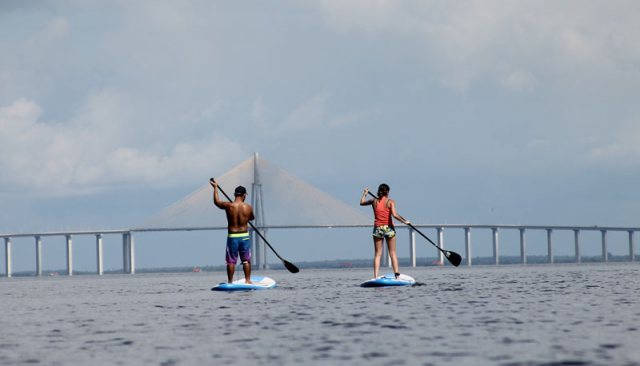 Deux brésiliens font du stand up paddle sur le rio negro